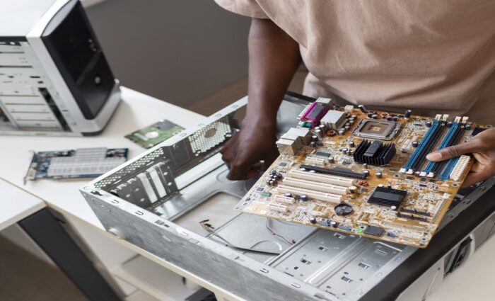 Technician repairing a desktop computer at a computer repair shop in Secunderabad.